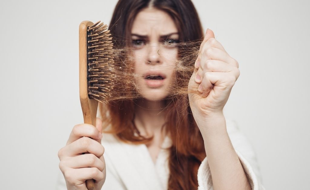 ragazza con spazzola piena di capelli